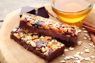 Ahşap masa üzerinde bir kapta bal ile lezzetli çikolata granola barlar