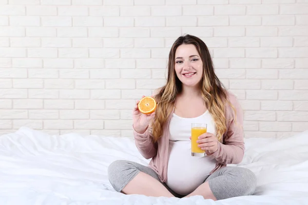 Mulher Grávida Bonita Com Suco Laranja Vidro Sentado Cama — Fotografia de Stock