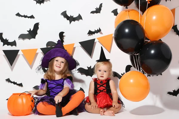 Niñas Trajes Halloween Con Globos Cubo Calabaza Sentado Sobre Fondo —  Fotos de Stock