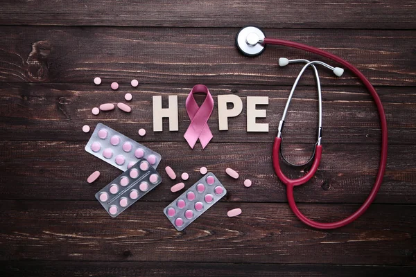 Roze Lint Met Pillen Stethoscoop Donkere Houten Achtergrond — Stockfoto