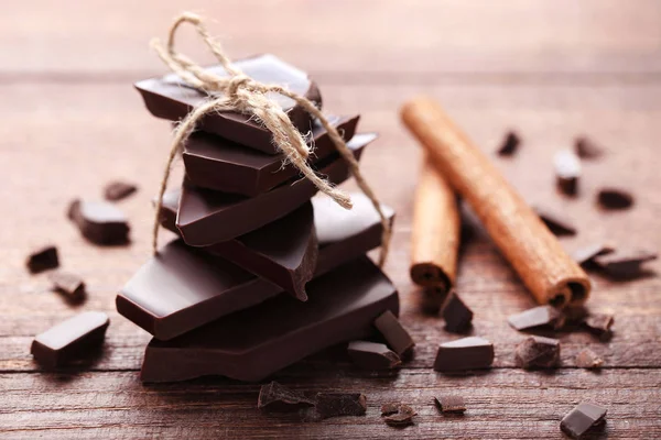 Ahşap masa üzerinde tarçın ile çikolata parçaları