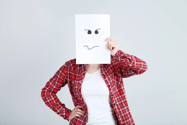 Dívka Drží Papír Nakreslenými Obličeji Šedém Pozadí — Stock fotografie