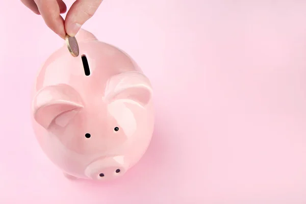 Female Hand Putting Coin Piggy Bank Pink Background — Stock Photo, Image