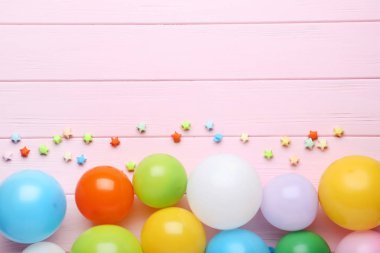 Pembe ahşap arka plan üzerinde renkli balon kağıt yıldız ile
