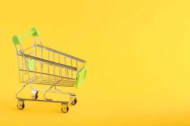 sarı arka plan üzerinde küçük alışveriş sepeti