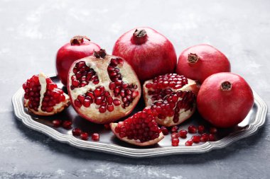 Adet gri arka plan üzerinde tepsisindeki olgun sulu nar