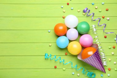 Yeşil ahşap arka plan üzerinde renkli balon Doğum günü kap ve kağıt yıldız ile