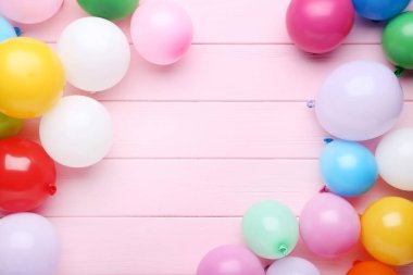 Pembe ahşap arka plan üzerinde renkli balonlar