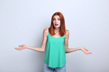 gri arka plan üzerinde duran karışık redhaired kadın