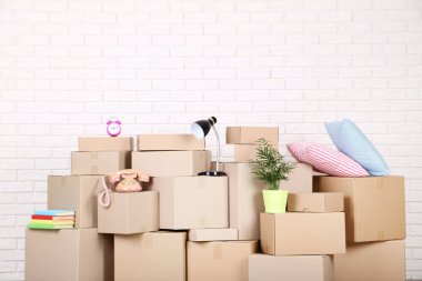 Tuğla duvar arka plan üzerinde ev malzeme ile karton kutular