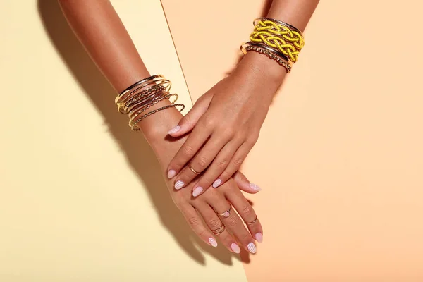 Frauenhände Mit Armbändern Und Ringen Auf Buntem Hintergrund — Stockfoto