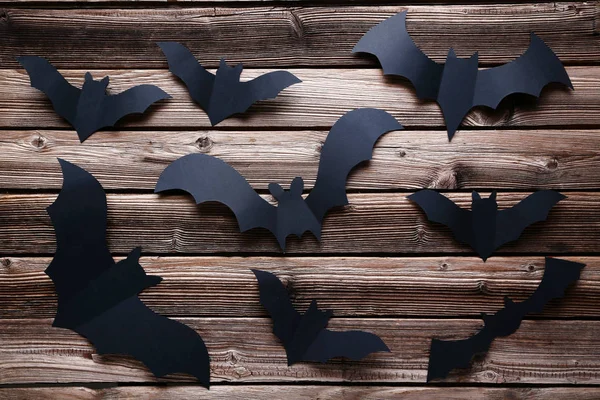 Halloween paper bats on brown wooden background