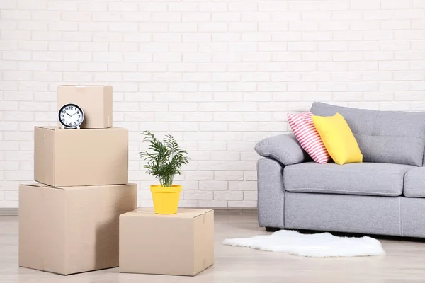 Cardboard Boxes Household Stuff Grey Sofa Brick Wall Background — Stock Photo, Image