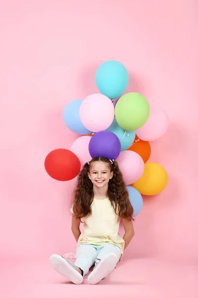 Menina Bonito Com Balões Coloridos Sentado Fundo Rosa — Fotografia de Stock