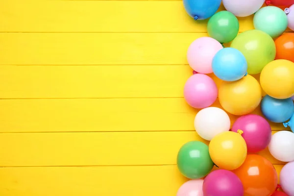 Sarı Ahşap Arka Plan Üzerinde Renkli Balonlar — Stok fotoğraf