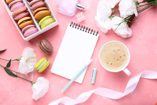 洋花和甜马卡龙的笔记本在粉红色背景下 — 图库照片