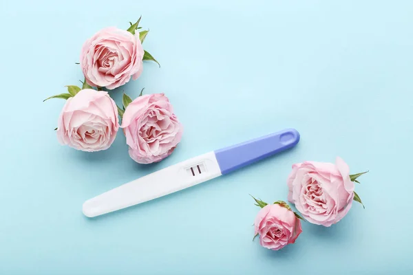 Schwangerschaftstest Mit Rosenblüten Auf Blauem Hintergrund — Stockfoto