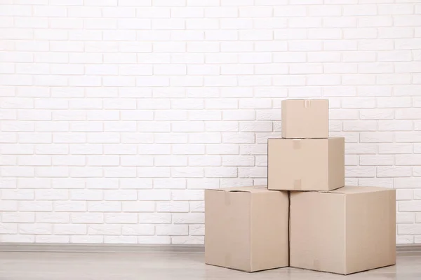 Stacked Cardboard Boxes Brick Wall Background — Stock Photo, Image