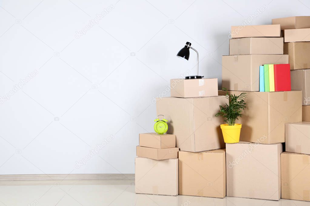 Cardboard boxes with household stuff on grey background