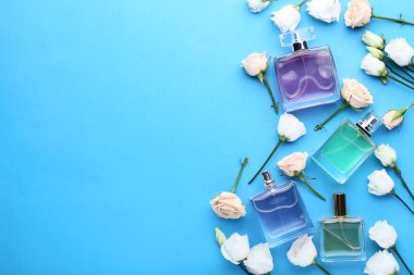 Gül ve eustoma çiçekler mavi zemin üzerine parfüm şişeleri