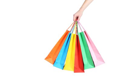 Beyaz arka plan üzerinde renkli alışveriş torbaları tutmak el