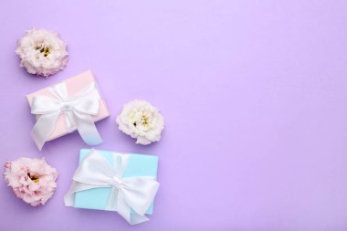 Hediye kutuları şeritler ve eustoma çiçekler mor zemin üzerine