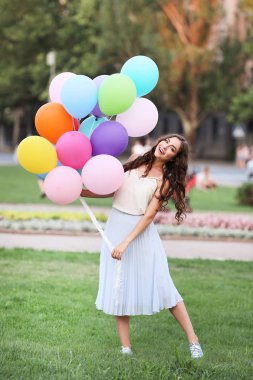 Güzel genç kız renkli balonlar park holding