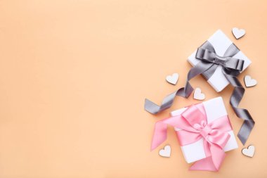 Hediye kutuları ile bej renkli arka plan üzerinde küçük kalpler