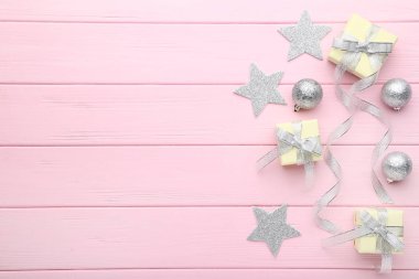 Gümüş baubles ve pembe ahşap arka plan üzerinde yıldız ile hediye kutuları