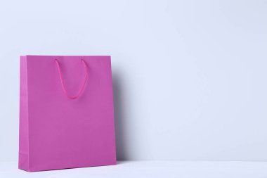 Gri arka plan üzerinde pembe alışveriş çantası