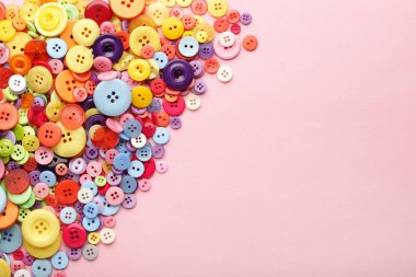 Pembe bir arka plan üzerinde renkli dikiş düğmeleri