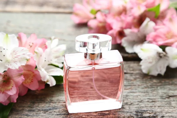 Parfümflasche Mit Alstroemeria Blüten Auf Grauem Holztisch — Stockfoto