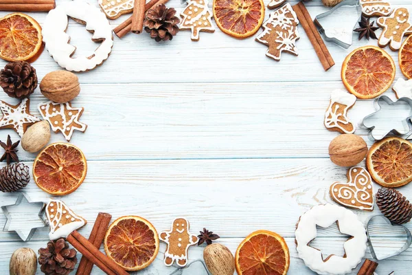 Christmas gingerbread cookies with dry oranges and walnuts on white wooden background
