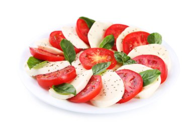 Mozzarella peyniri, domates ve fesleğen yaprakları beyaz arka plan üzerinde izole plaka üzerinde