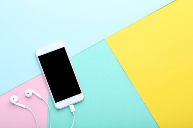Renkli arka plan üzerinde kulaklık ile Smartphone