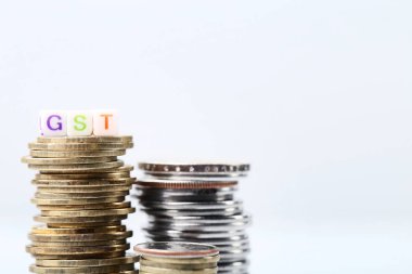 GST sikke yığını ile gri arka plan üzerinde kelime.