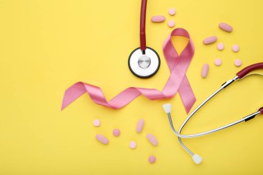 Pembe kurdele hapları ve sarı zemin üzerine stetoskop ile