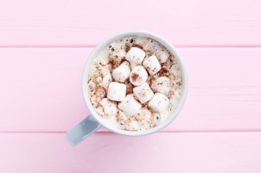 Kapuçino Kupası pembe ahşap masa üzerinde marshmallow ile