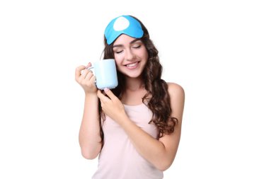Uyku maskesi ve beyaz arka plan üzerinde çay ile güzel kız