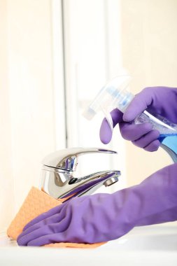 Ellerinde eldiven sünger ve banyo musluk suyu temizlik deterjan şişe