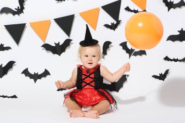 Bebek kız halloween kılık ve beyaz arka plan üzerinde balon