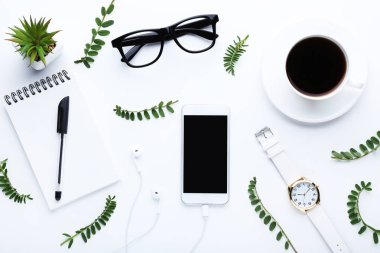 Kulaklık, kahve, beyaz zemin üzerine defter ve yeşil sapları ile Smartphone