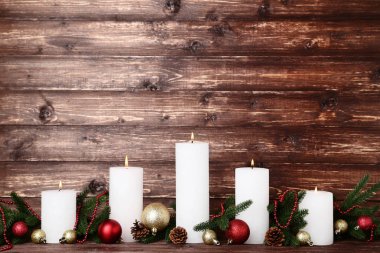 Köknar ağaç dalları ve baubles kahverengi zemin üzerine beyaz Noel mumlar