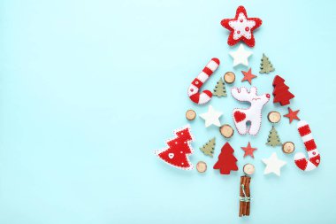 Mavi arka plan üzerinde Noel ağacı şeklinde küçük yumuşak oyuncaklar