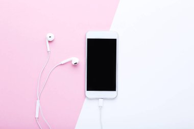 Pembe ve beyaz arka plan üzerinde kulaklık ile Smartphone