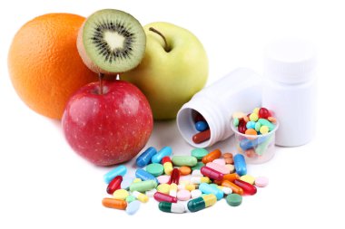 Olgunlaşmış meyve ve beyaz arka plan üzerinde renkli hapları