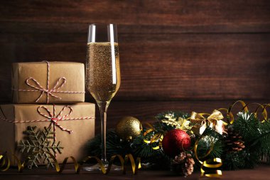 Hediye kutuları ve Noel süslemeleri ile şampanya kadehi
