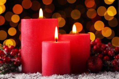 Biblo ve ışıklar arka plan üzerinde kırmızı meyveler ile Noel mumlar