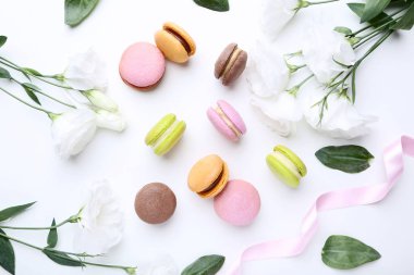 Beyaz arka plan üzerinde eustoma çiçekli tatlı macarons