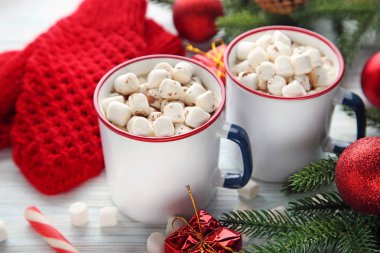 Kapuçino hatmi kupalar ve ahşap masa üzerinde köknar ağacı dalları ile